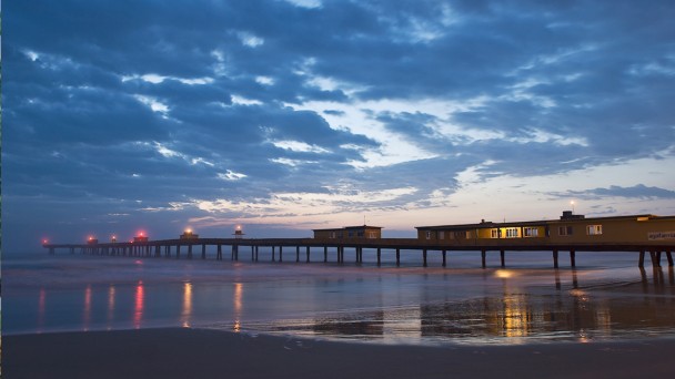 Plataforma de pesca de Tramandaí, Rio Grande do Sul, ao entardecer, sob céu nublado.